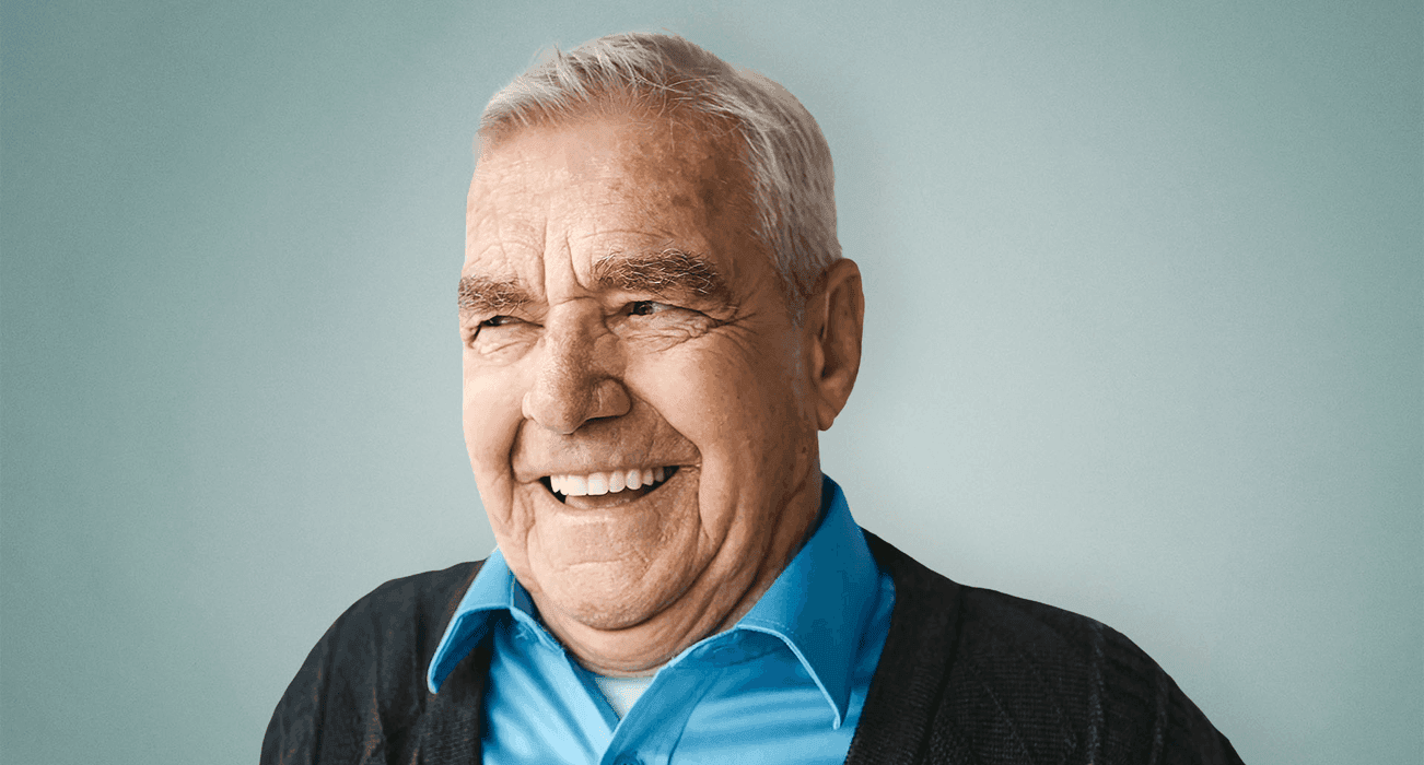 A headshot of a man looking away from the camera and smiling