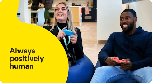 A photo of two employees who are having fun playing Nintendo Switch in the office entertainment area